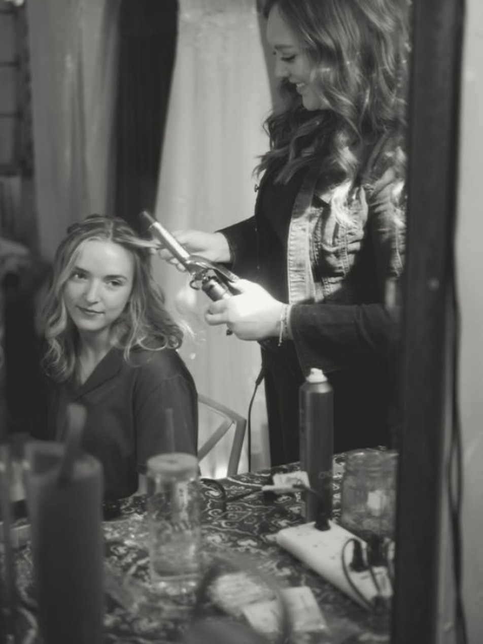Hannah curling a client's hair
